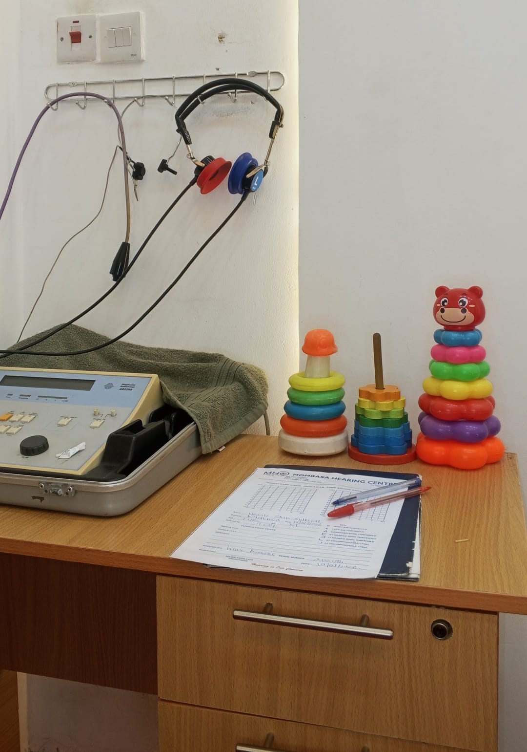 Paediatric audiometry station with children's headphones, audiometer and stacking-ring play toys