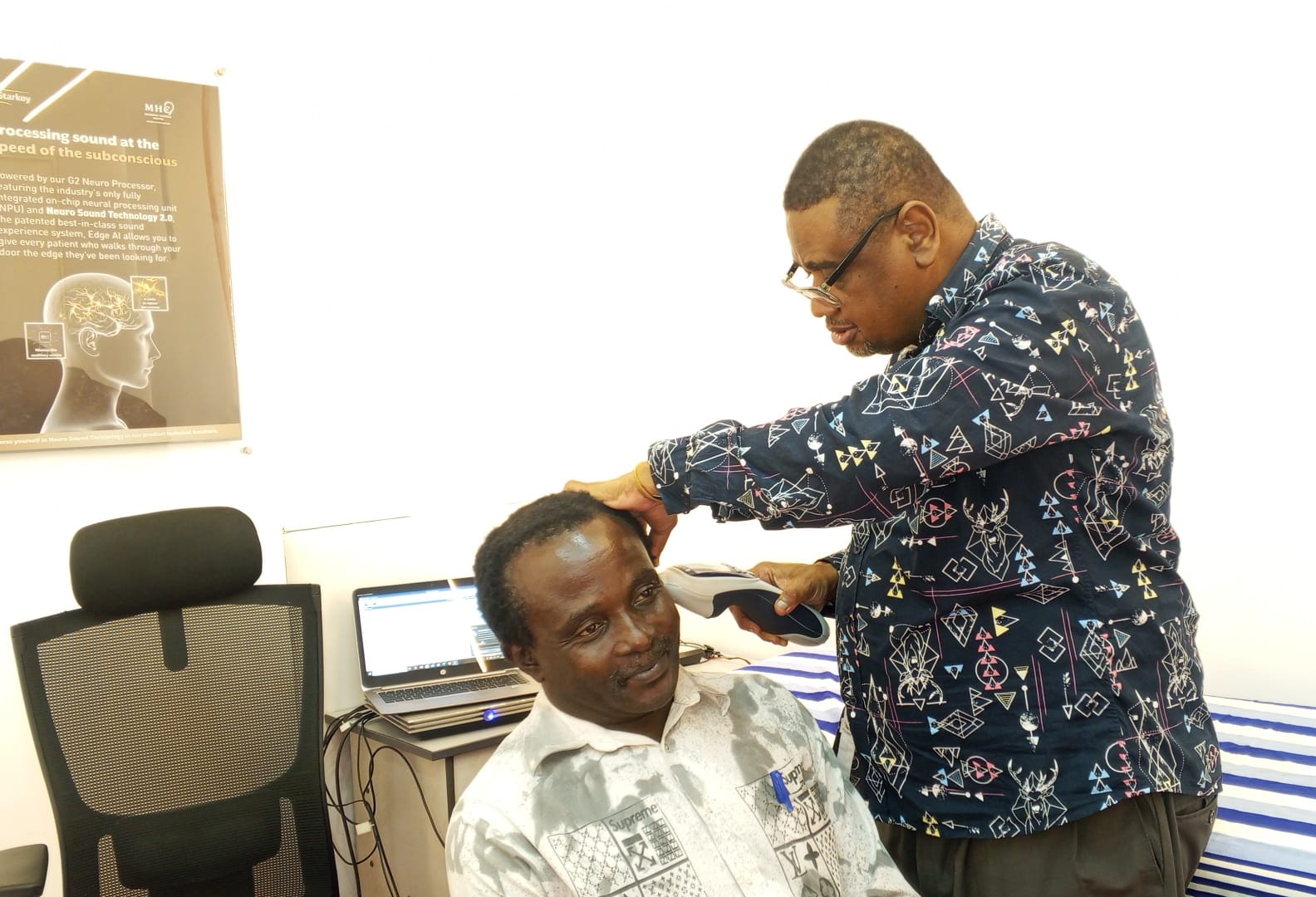 Lead audiologist performing tympanometry on a patient's right ear